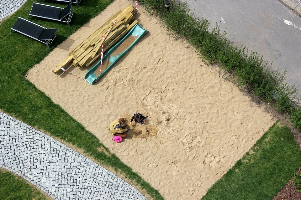 Anak bermain pasir di sandbox playground - pengalaman bermain yang menjadi dasar wahana excavator mini