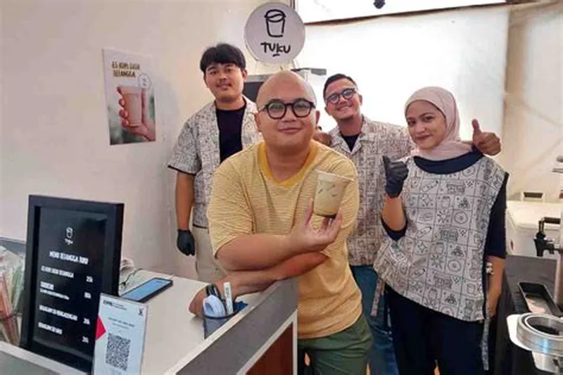 Andanu Prasetyo Founder Toko Kopi Tuku dan CEO MAKA Group bersama tim barista di depan kedai kopi Tuku