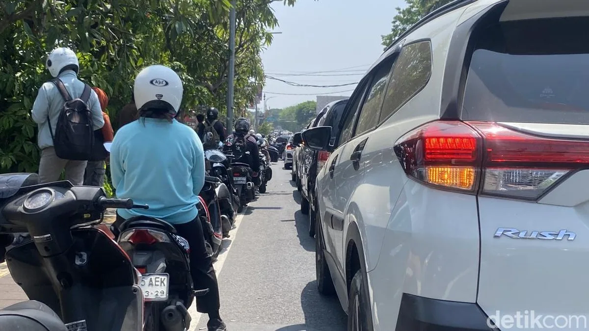 Warga dan pengendara sepeda motor mengantre panjang mengisi BBM di salah satu SPBU di Denpasar Bali