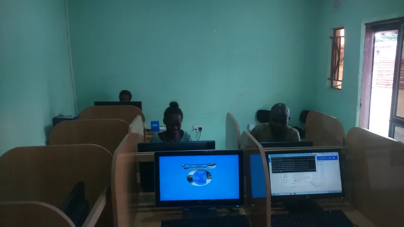 Warnet atau internet cafe dengan deretan komputer dan pengunjung yang sedang menggunakan internet