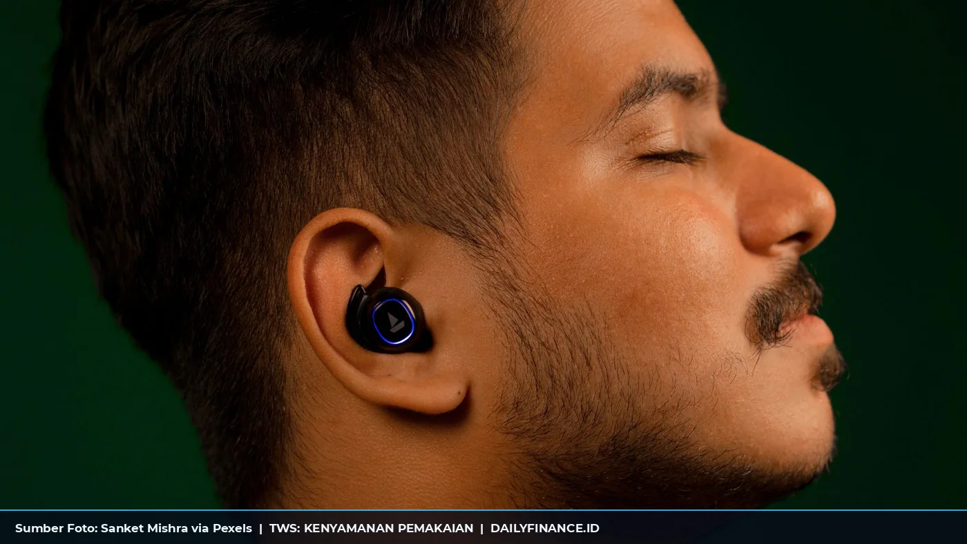 Pria memakai earbud nirkabel hitam dengan latar hijau