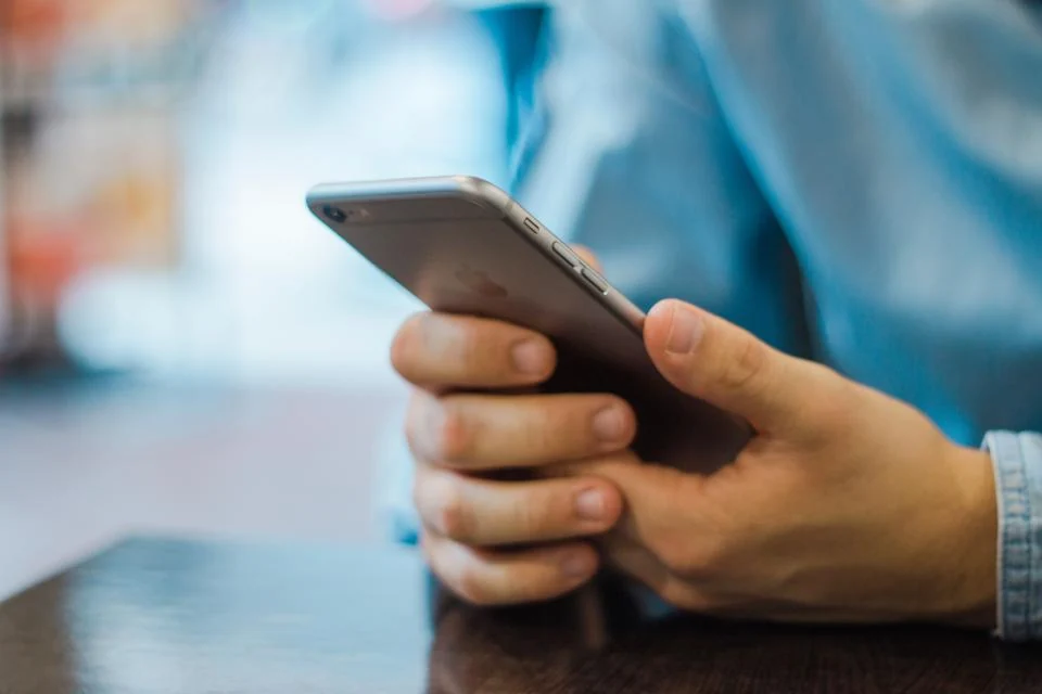 Tangan memegang smartphone untuk mengecek status penerima BSU 2026 secara online