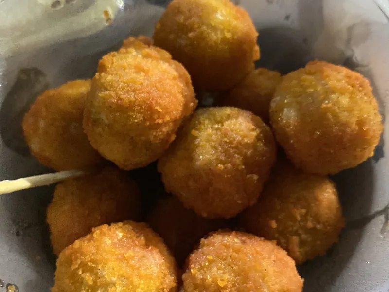 Semangkuk berisi cimol goreng berwarna keemasan dengan isian keju dan tusuk gigi kayu