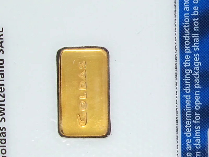Batang emas satu gram bertuliskan merek Goldas di dalam kartu sertifikat assay transparan