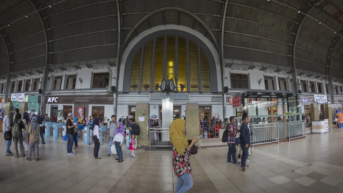 Suasana hall Stasiun Jakarta Kota dengan penumpang yang berjalan menuju peron