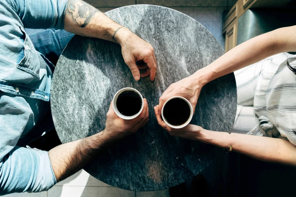 Dua orang berbincang santai dengan kopi melambangkan percakapan jujur soal utang pinjol