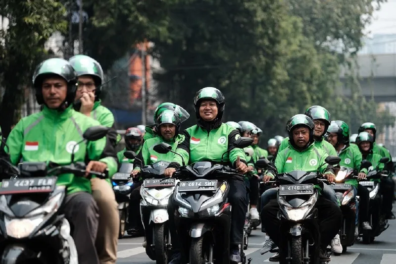 Barisan pengemudi ojek online ojol konvoi di jalan raya menantikan kepastian regulasi potongan aplikasi