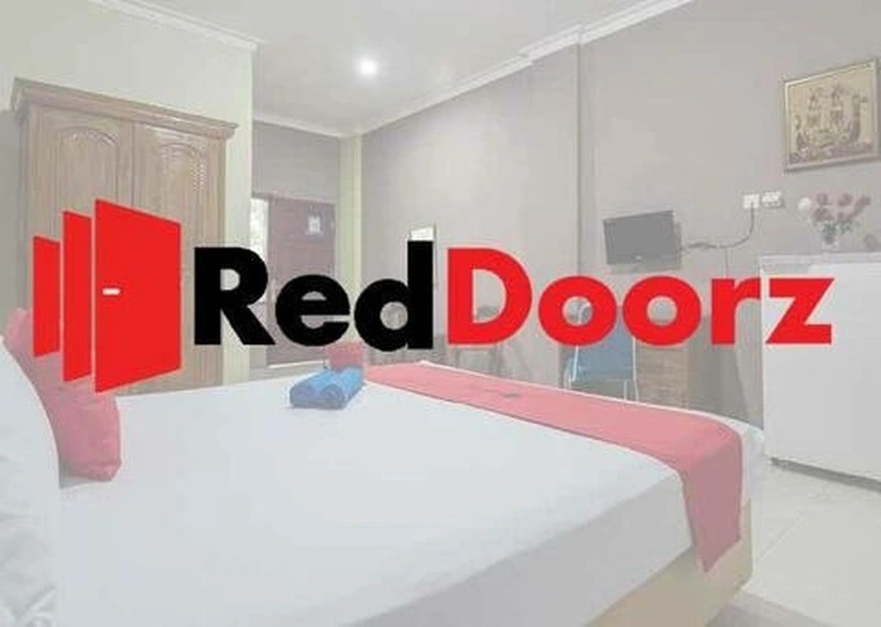 Kamar hotel budget RedDoorz dengan linen putih dan aksen merah khas
