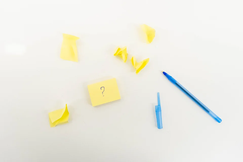 Sticky notes kuning berisi tanda tanya di meja putih sebagai pengingat tagihan